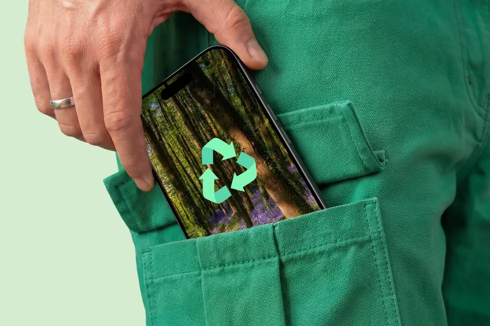 Téléphone affichant le symbole du recyclage, glissé dans une poche